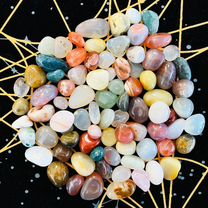 A heap of small polished mixed agates in every colour on the velvet cloth