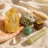 Money Magnet Mindset crystal kit on cream linen with the Generator citrine as centerpiece, plus pyrite cluster, tiger's eye sphere, green aventurine sphere, clear quartz wand, and Afghan jade point.