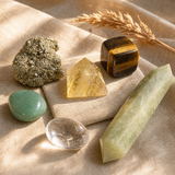 Money Magnet Mindset crystal kit on cream linen with the Small Pyramid citrine as centerpiece, plus pyrite cluster, tiger's eye sphere, green aventurine sphere, clear quartz wand, and Afghan jade point.